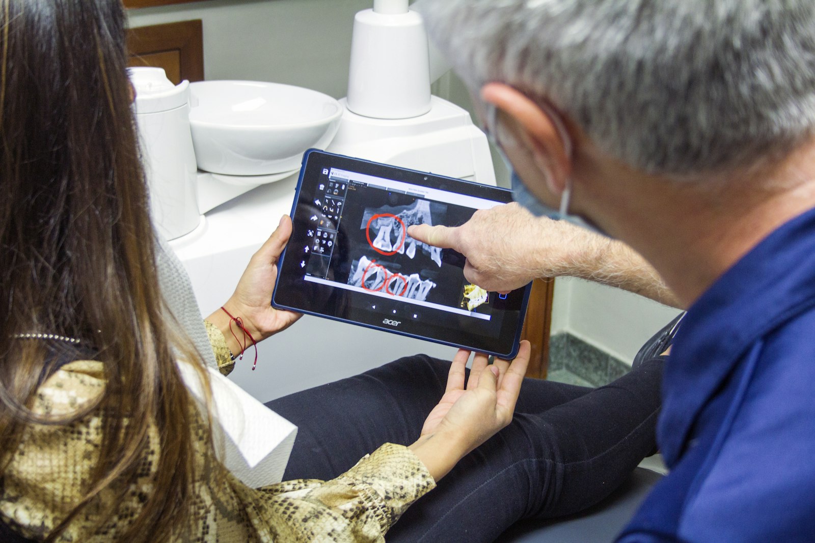 Zahnarzt erklärt ein Röntgenbild auf dem Tablet